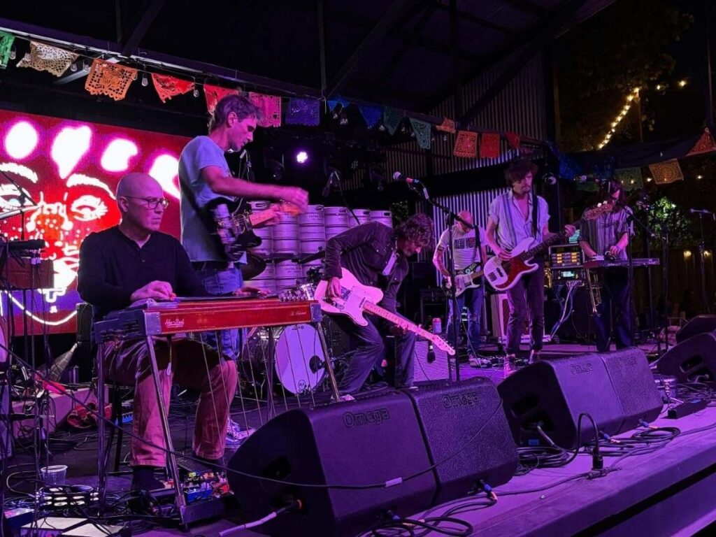 A small Austin live music venue with a close-up performance and warm stage lighting