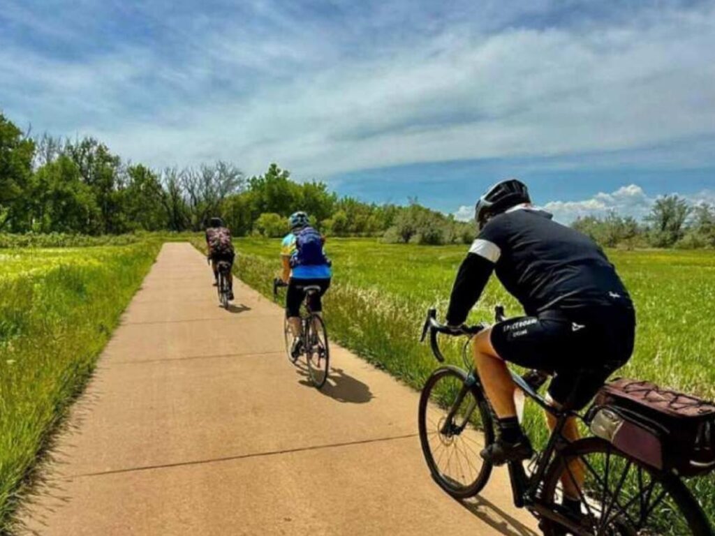 Cyclist riding along the Cherry Creek Trail in Denver on a clear day.