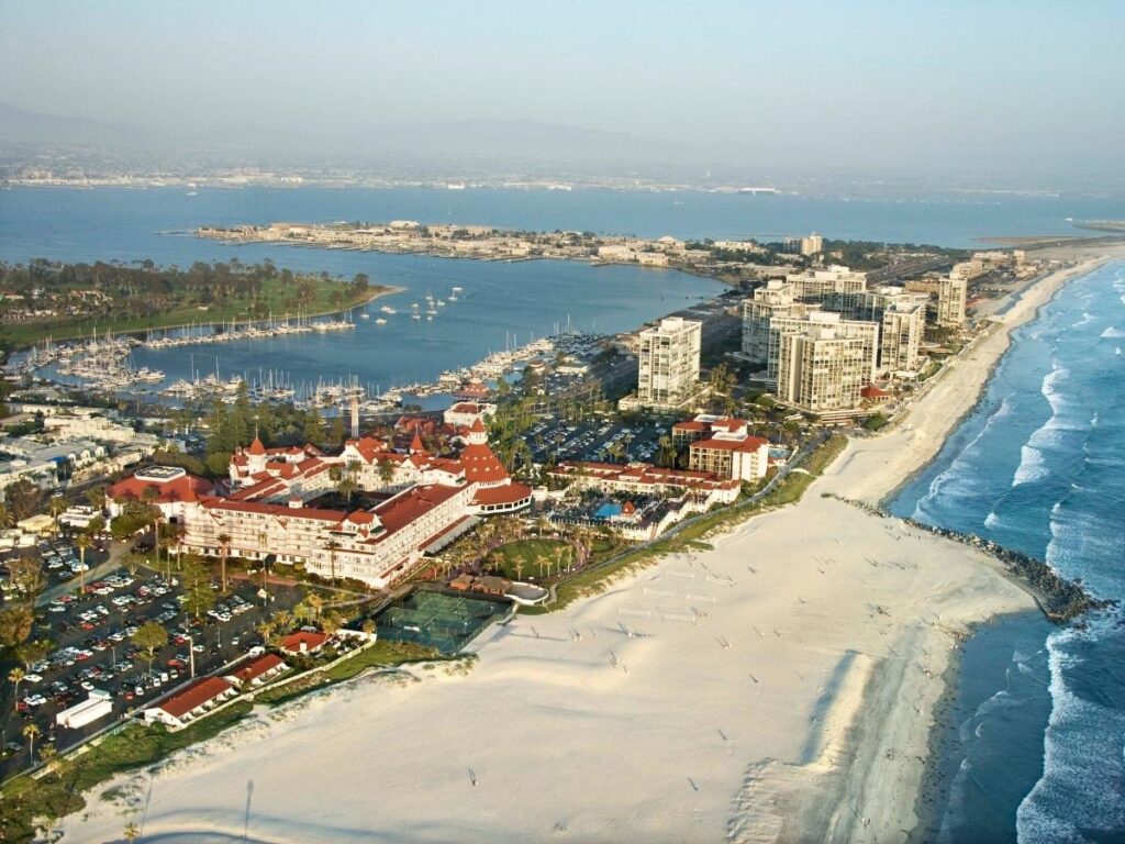 Wide sandy shoreline of Coronado Beach with ocean waves and Hotel del Coronado.