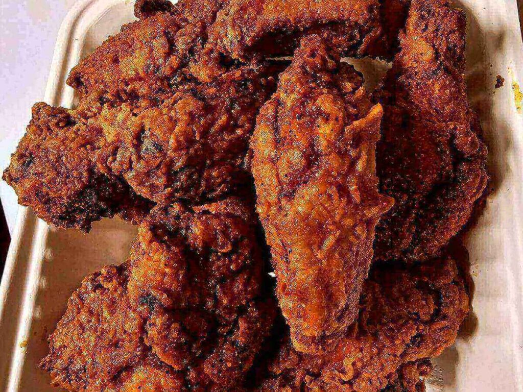 Nashville hot chicken served with pickles and white bread