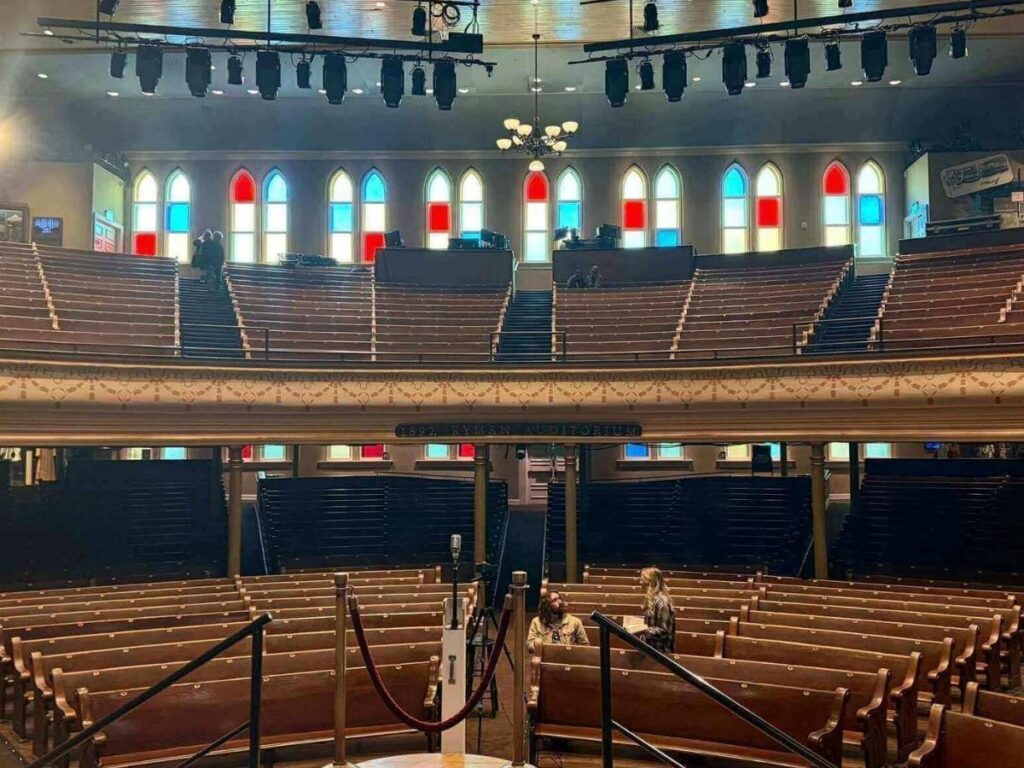 Inside the historic Ryman Auditorium with wooden pew seating