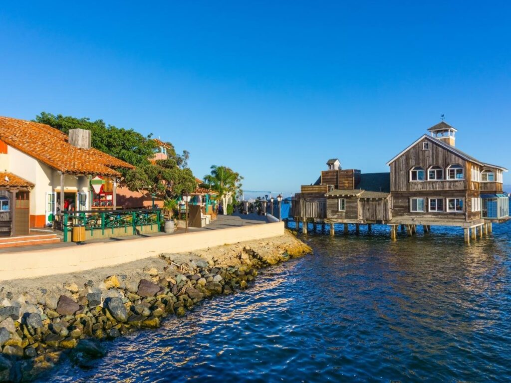 Waterfront walkway with shops and palm trees at Seaport Village in San Diego.