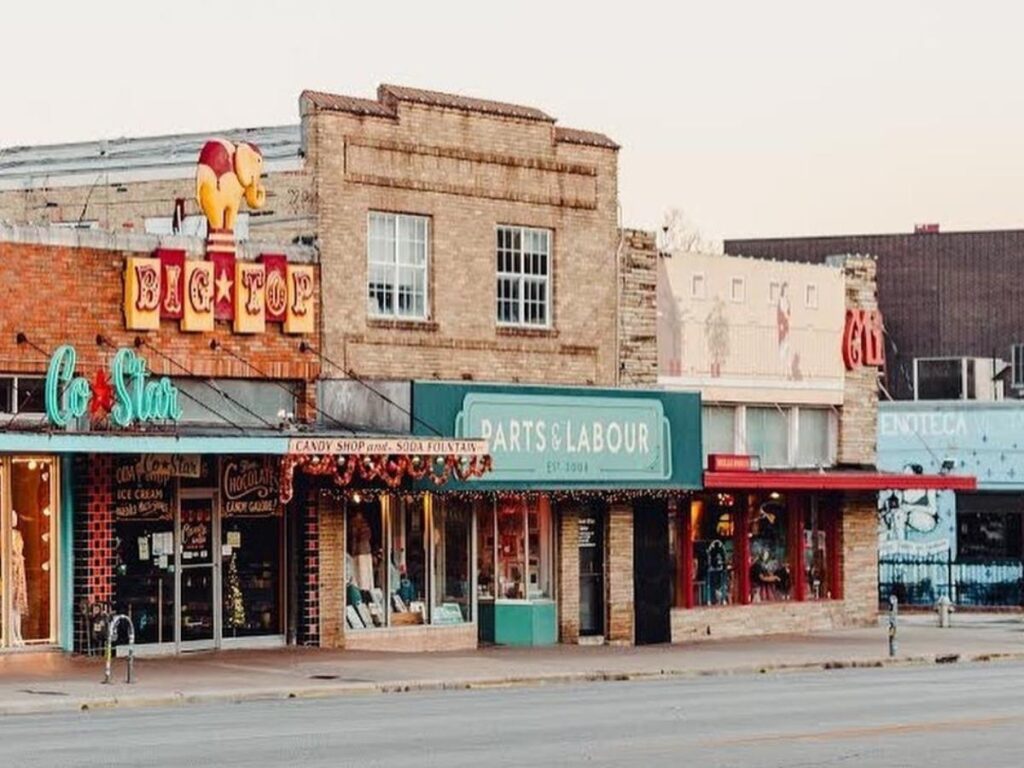 The “I Love You So Much” mural on South Congress with people walking by and cafés nearby.