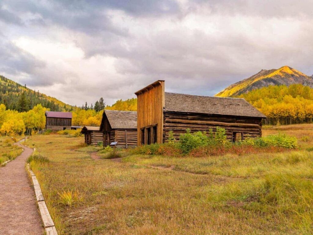 Weathered wooden buildings of Ashcroft Ghost Town framed by high mountain peaks