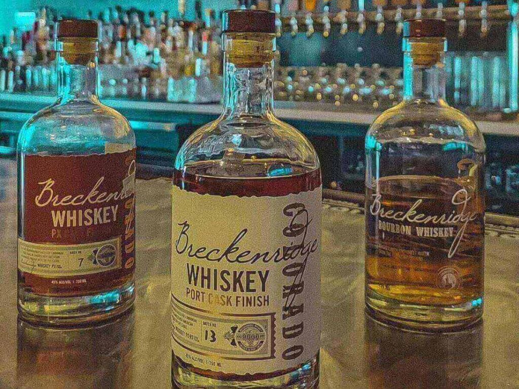 Inside the Breckenridge Distillery tasting room with bottles and bar seating.