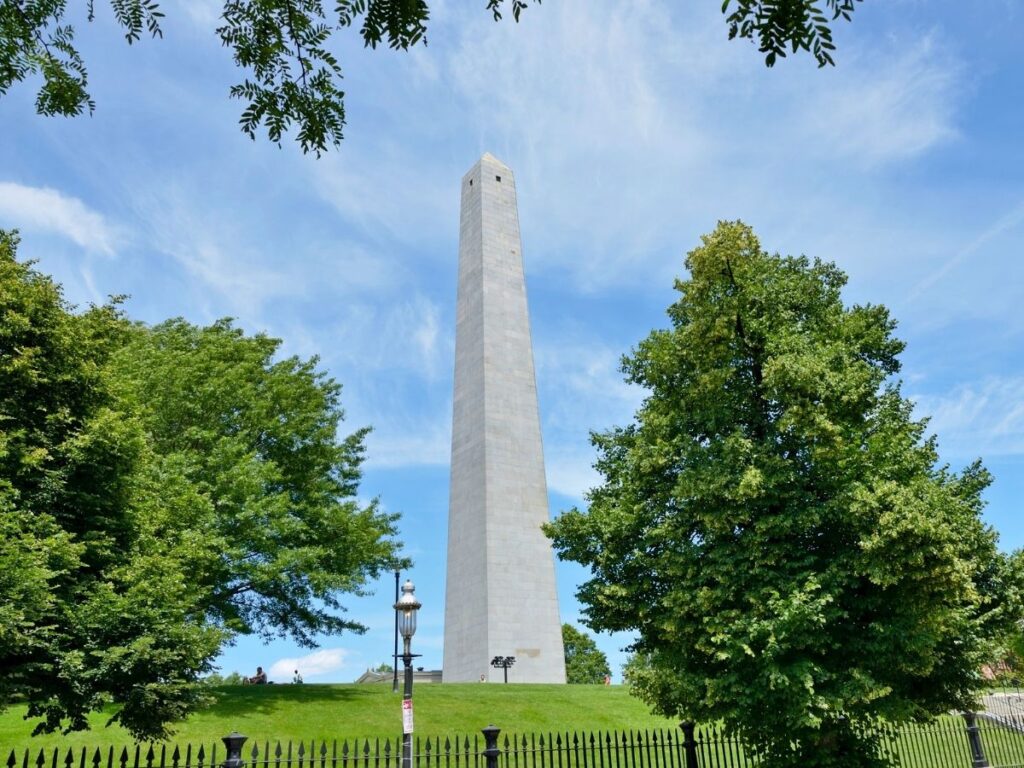 Tall granite Bunker Hill Monument with blue sky in Boston