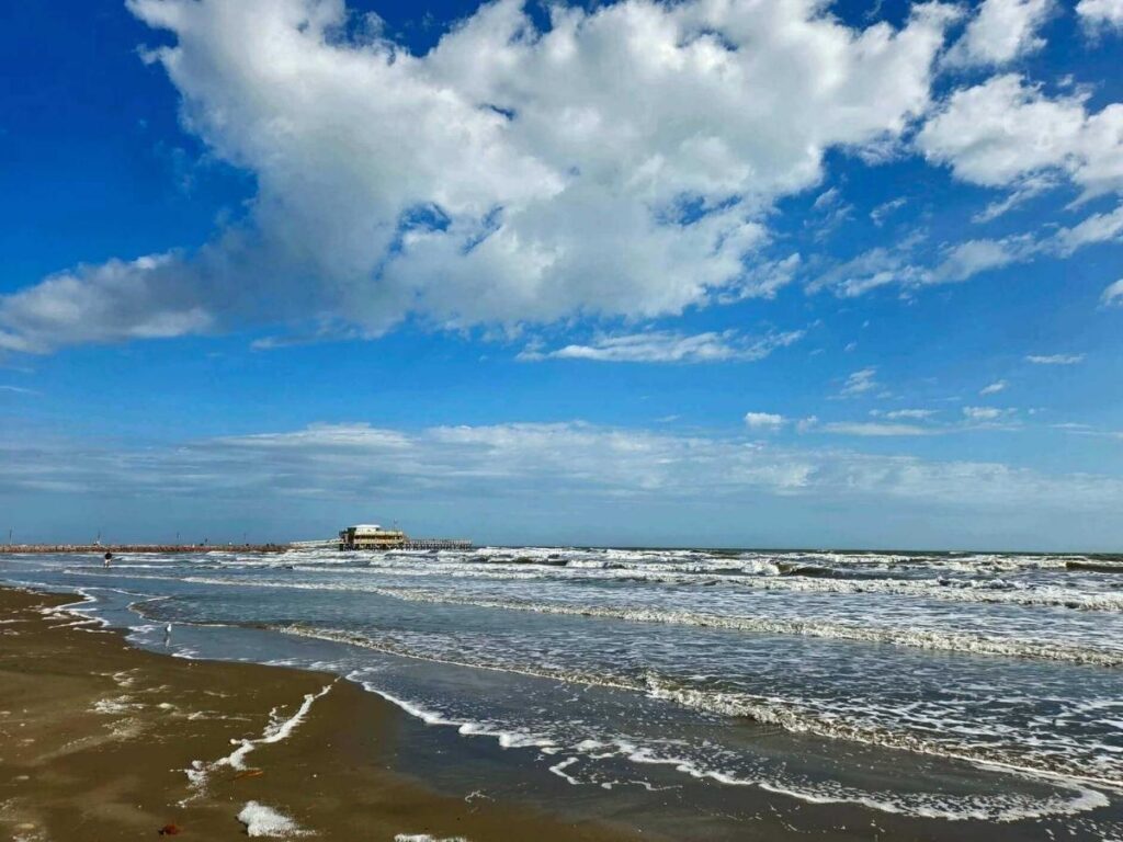 Spacious coastline at East Beach in Galveston with soft sand and open blue sky.