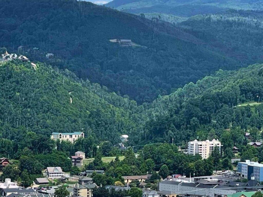 Gatlinburg Parkway lined with shops and attractions with mountains in the background.
