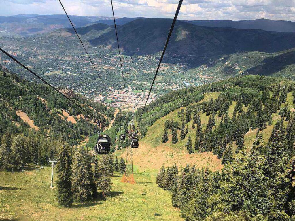 Silver Queen Gondola rising above Aspen in the early morning light with mountains in the background