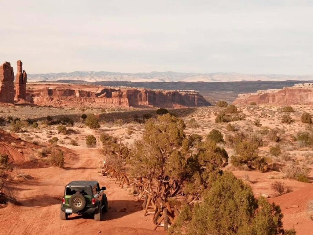 Scenic road leading into Moab with red rock cliffs and wide open desert views