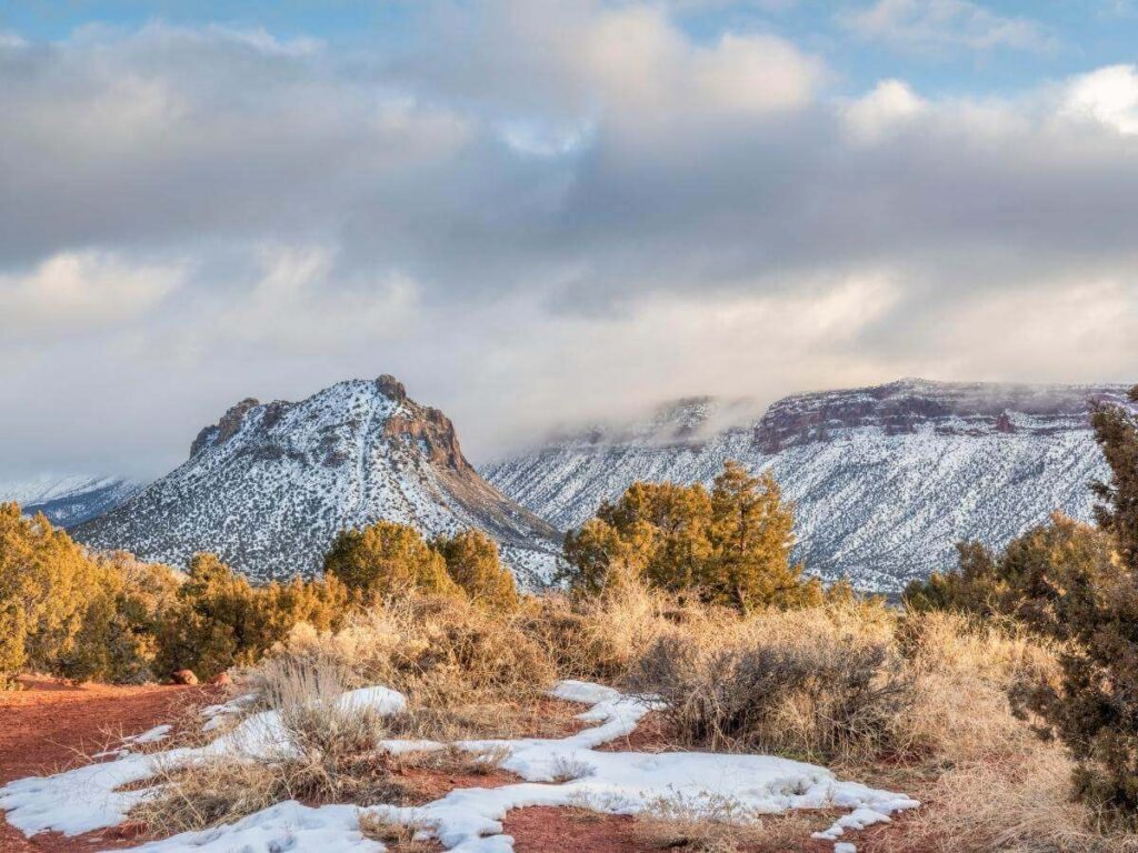 Light snow dusting red rock formations near Moab in winter