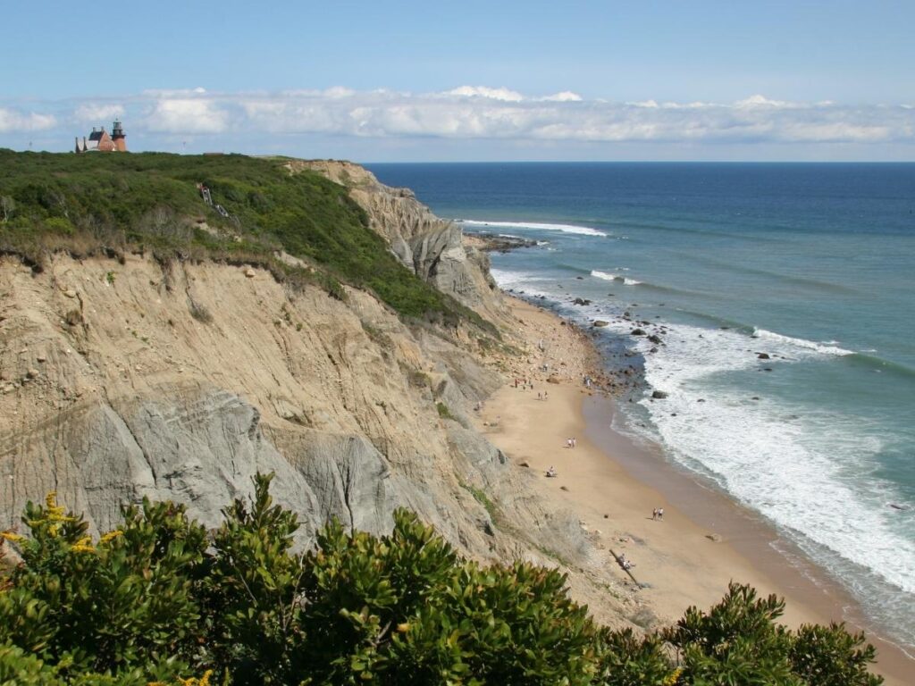 View of Mohegan Bluffs cliffs overlooking bright blue ocean.
