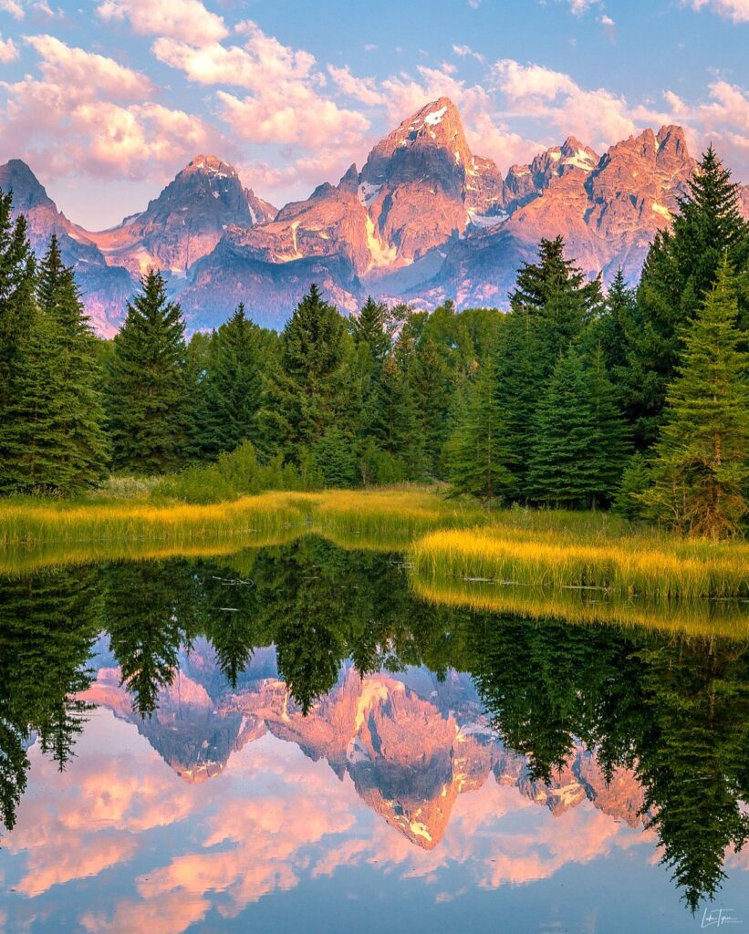 Reflections of the Teton mountains in the still water at Schwabacher Landing during sunset