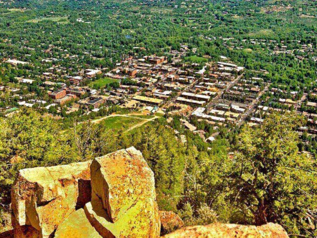 View from Ute Rock looking over Aspen with the town below and mountains beyond at sunset