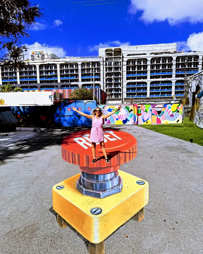 Colorful graffiti mural at Wynwood Walls in Miami with visitors exploring the art district.