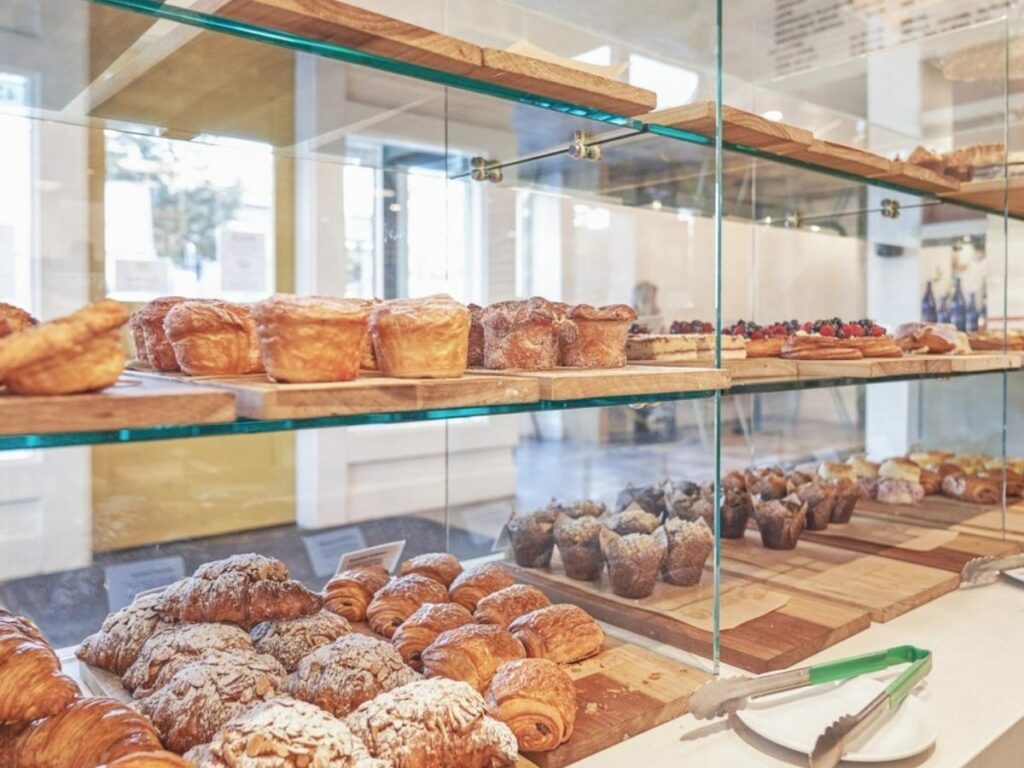 Warm croissants and pastries displayed in a bakery window on Ocean Avenue