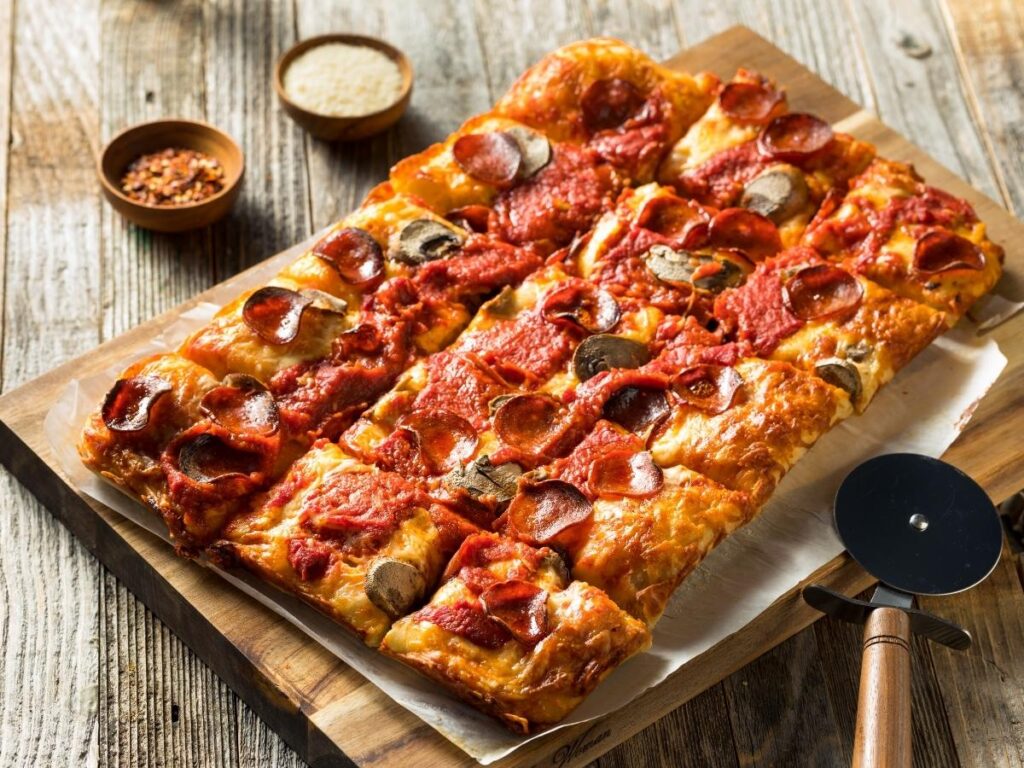 Square pan Detroit-style pizza with crispy crust and cheese.