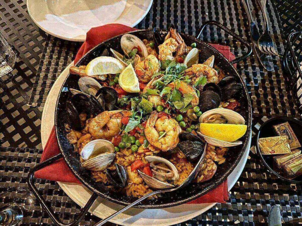 Colorful seafood paella served outdoors at Espana Restaurant & Tapas in Fernandina Beach