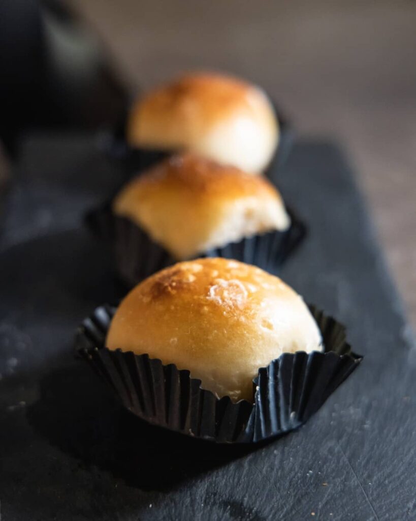 A powdered sugar-covered cream bun (fiocco di neve) pastry on a cafe plate in Naples