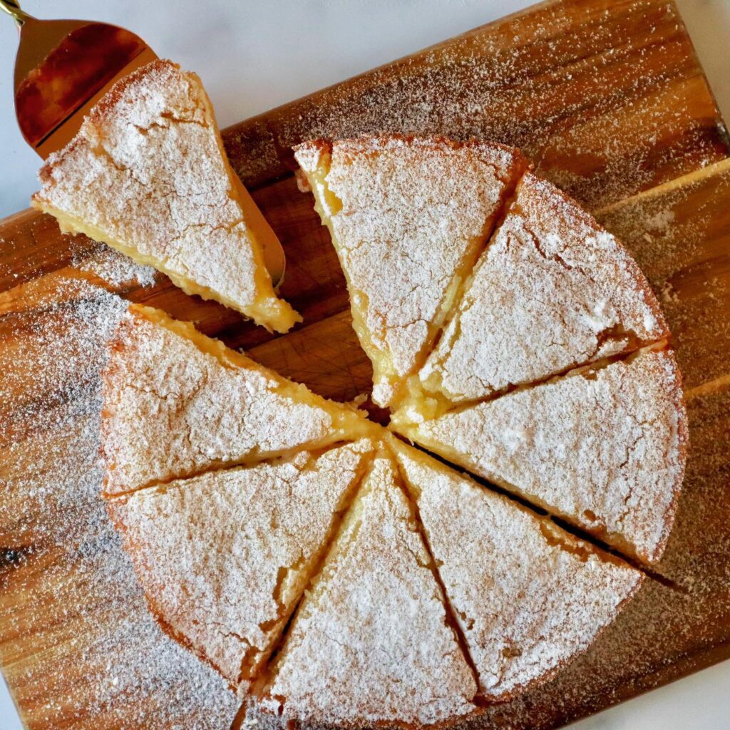 Gooey butter cake slice on a white plate with powdered sugar at a St. Louis café