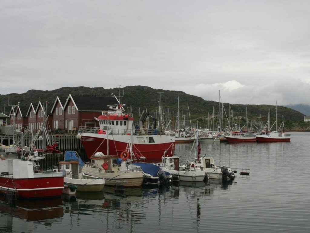 Boats moored in Harbour Village with shops and walkways in the background