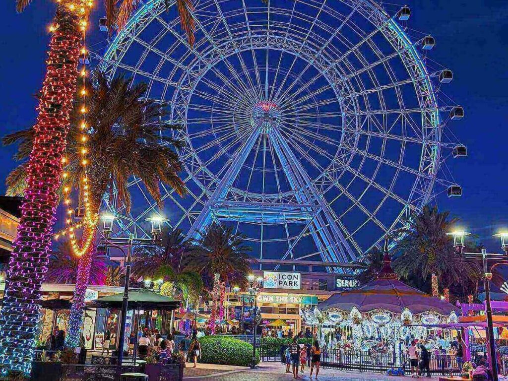 ICON Park in Orlando during the evening with lights and people walking around
