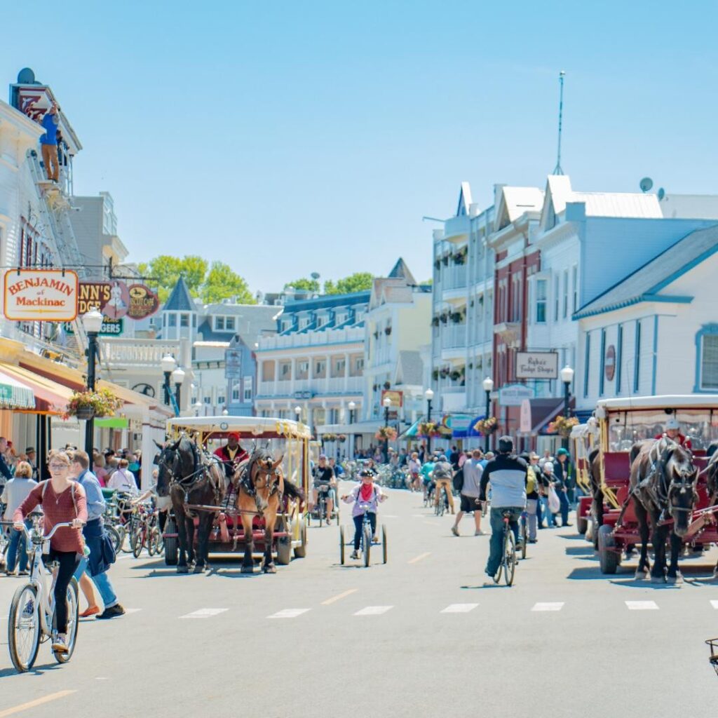 Colorful storefronts and horse-drawn carriages along Main Street in downtown Mackinac Island