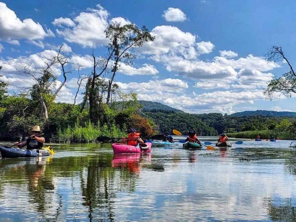 Kayakers paddling through the marsh at sunrise on Bald Head Island.