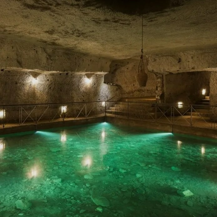 Underground passage with candlelight and brick walls during a Napoli Sotterranea tour