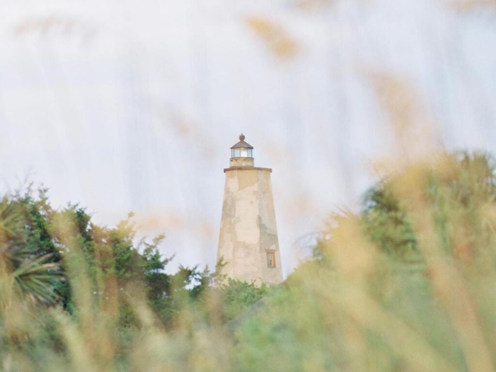 Old Baldy lighthouse framed by live oaks on Bald Head Island.