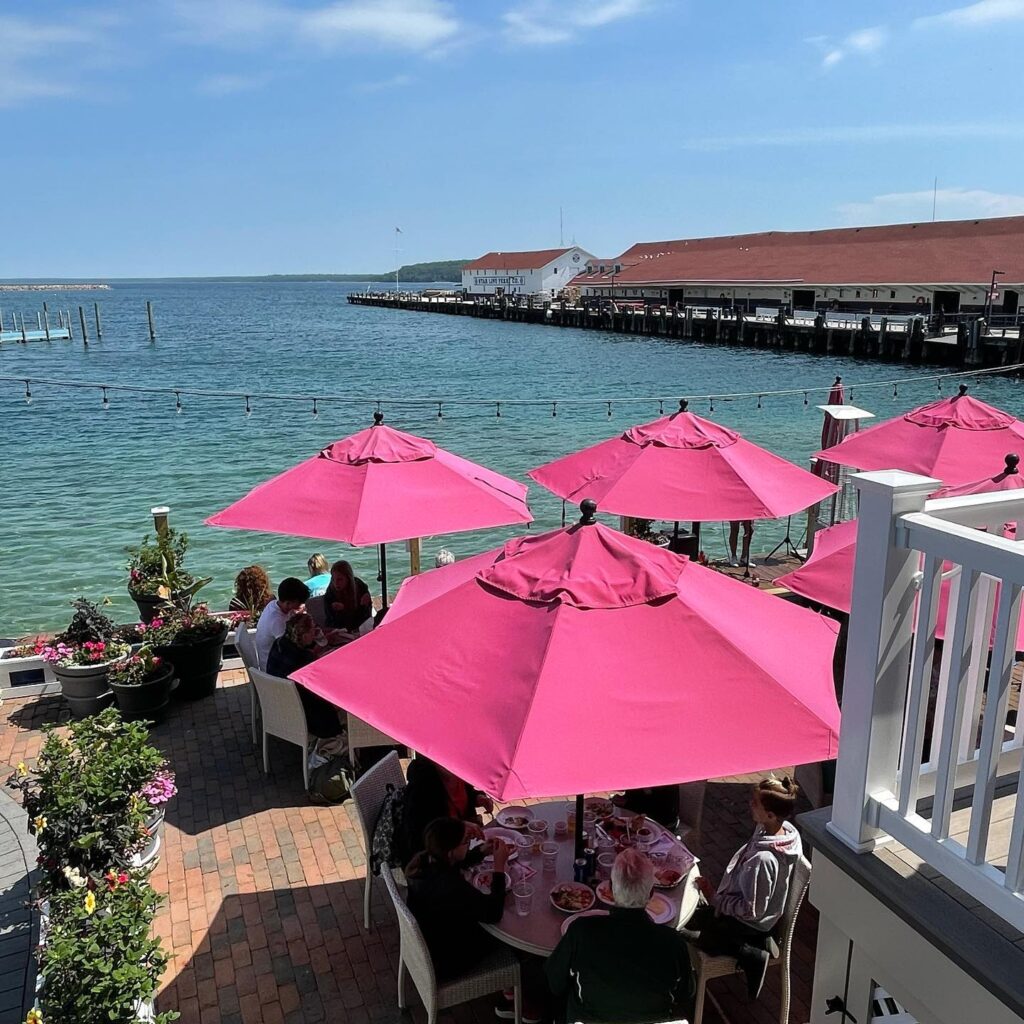 Outdoor dining at Pink Pony restaurant on Mackinac Island with harbor views