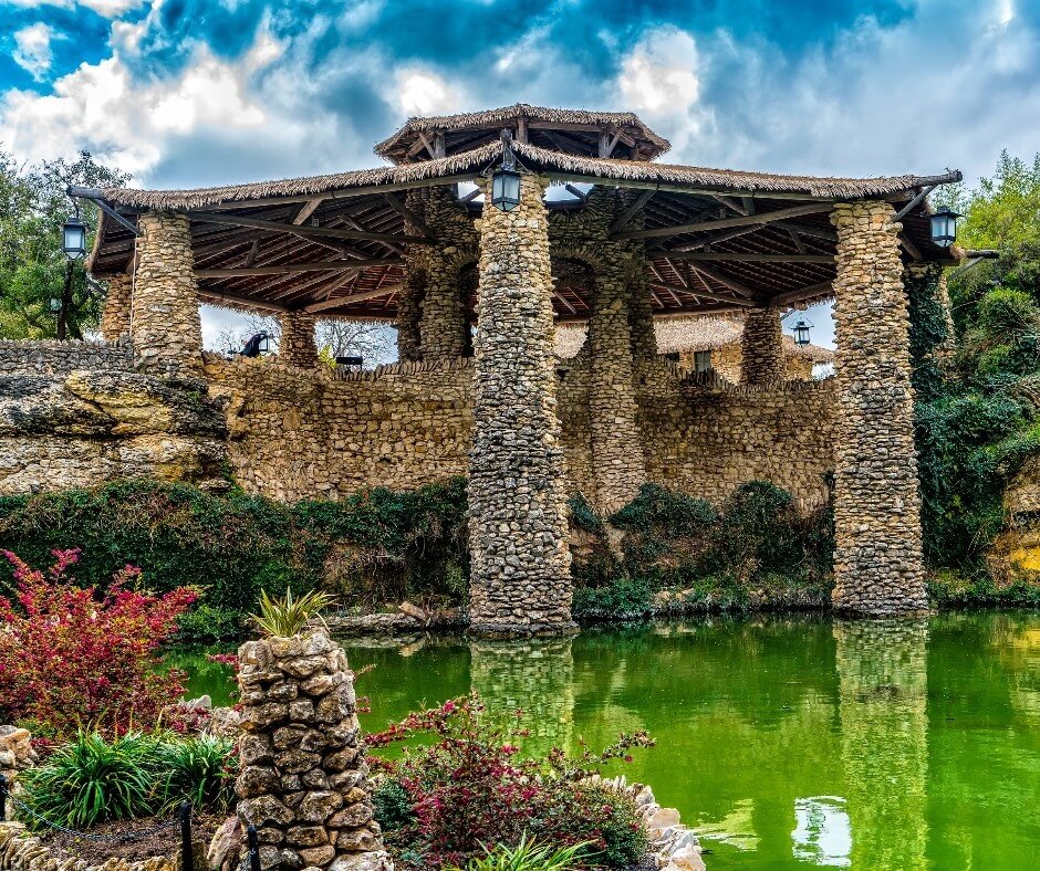 Stone bridge and koi pond in San Antonio’s Japanese Tea Garden surrounded by greenery