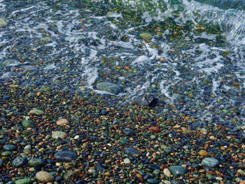 Empty pebble beach in the San Juan Islands with driftwood and calm water