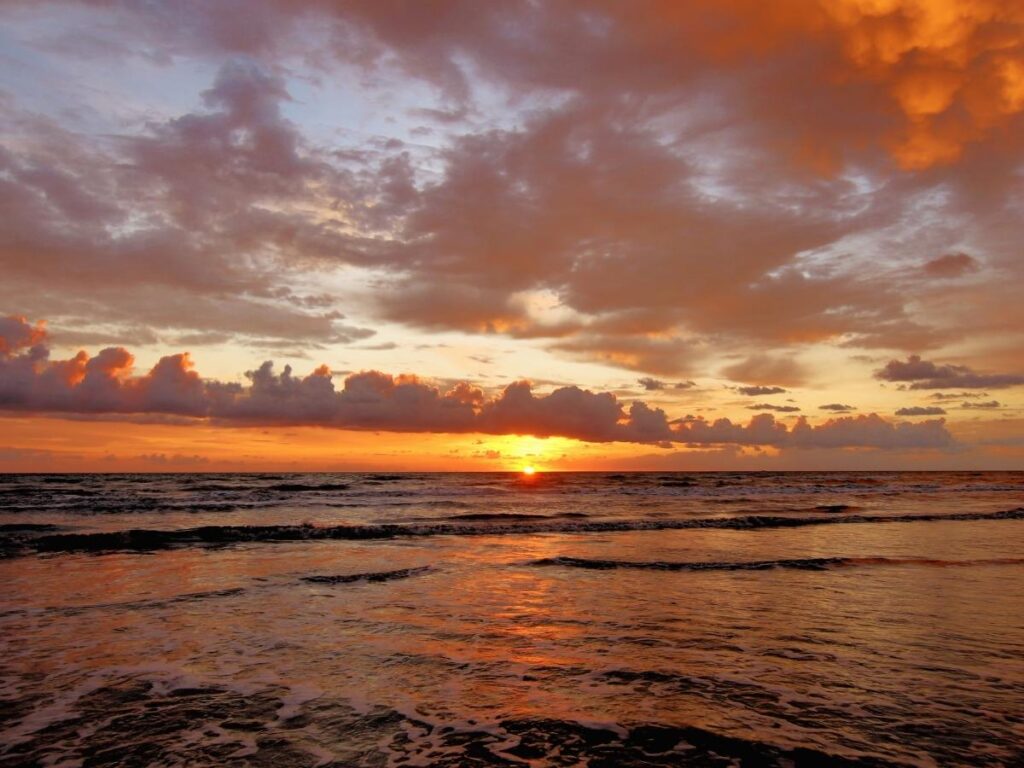 Sunset over the water viewed from the beach in South Padre Island