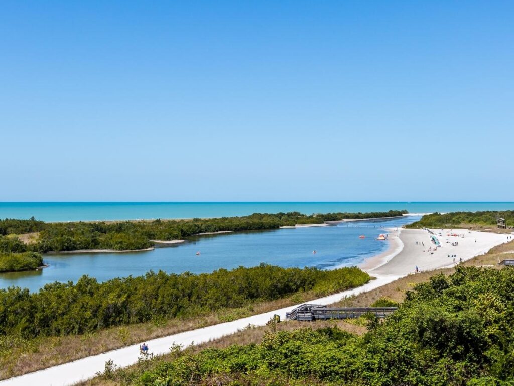 Walking across the shallow lagoon at Tigertail Beach toward the open shoreline