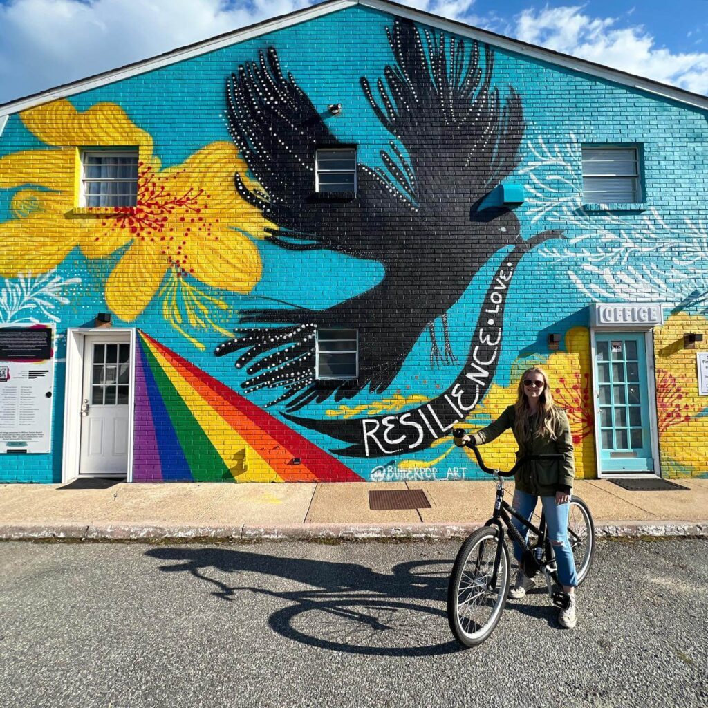Traveler in front of vibrant mural in ViBe Creative District