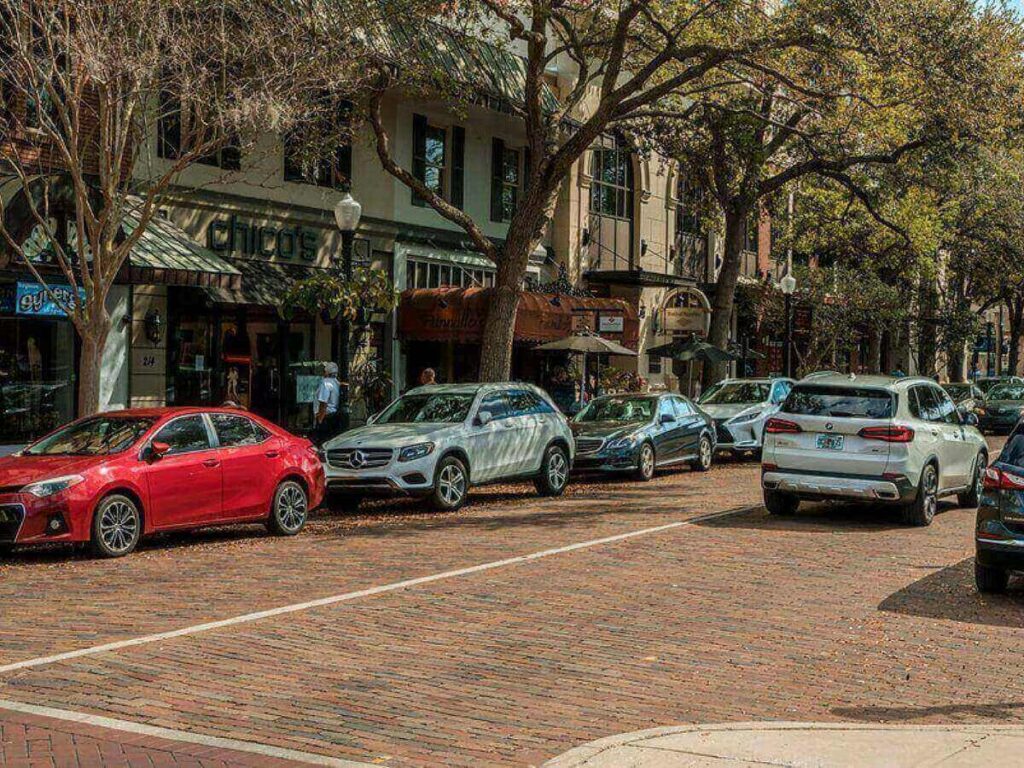 Tree-lined street in Winter Park, Orlando with people walking and outdoor seating