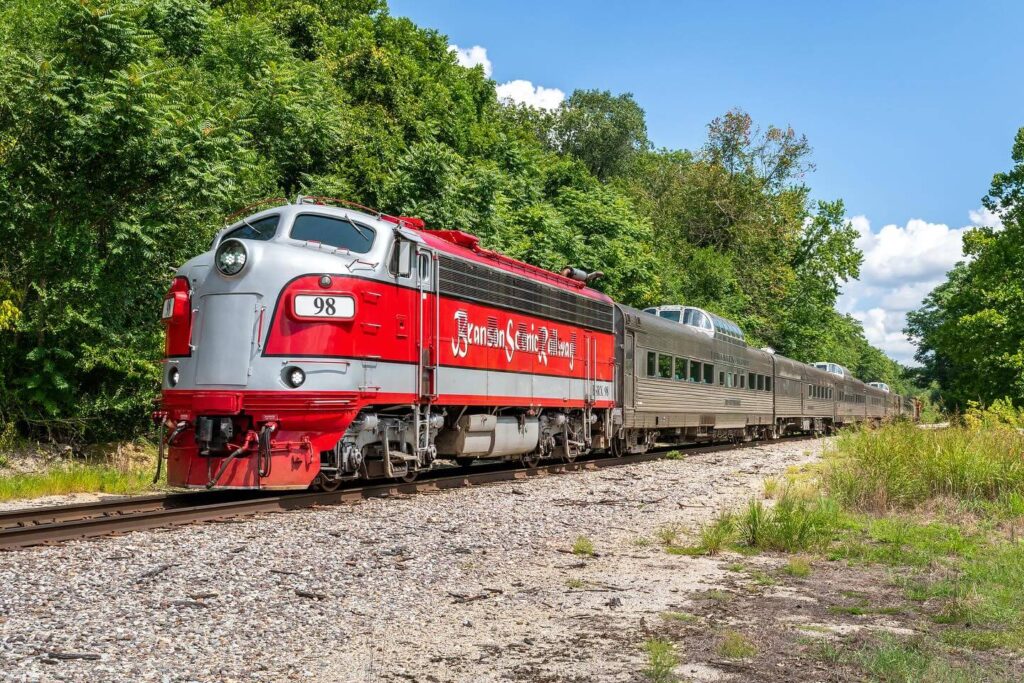 Vintage passenger train of Branson Scenic Railway traveling through Ozark foothills.