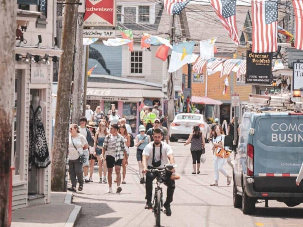 Commercial Street in Provincetown in the evening with string lights and people walking