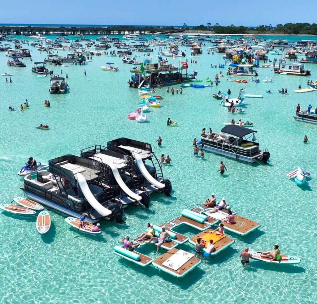 Visitors enjoying the shallow waters of Crab Island from pontoon boats
