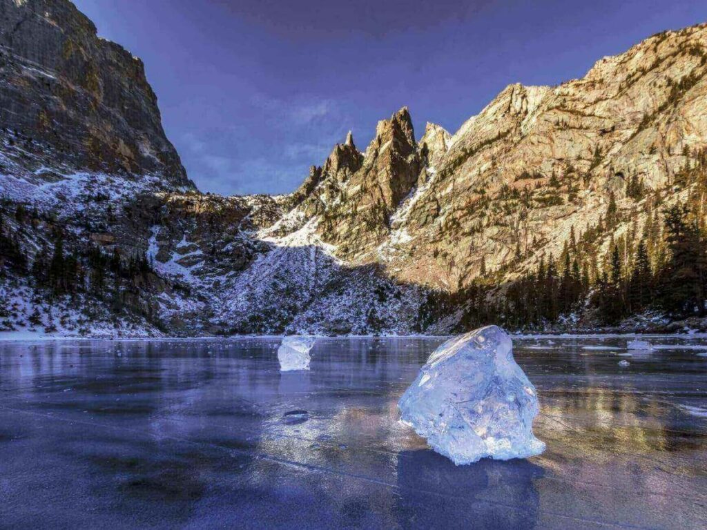 Emerald Lake beneath steep rocky cliffs in Rocky Mountain National Park.