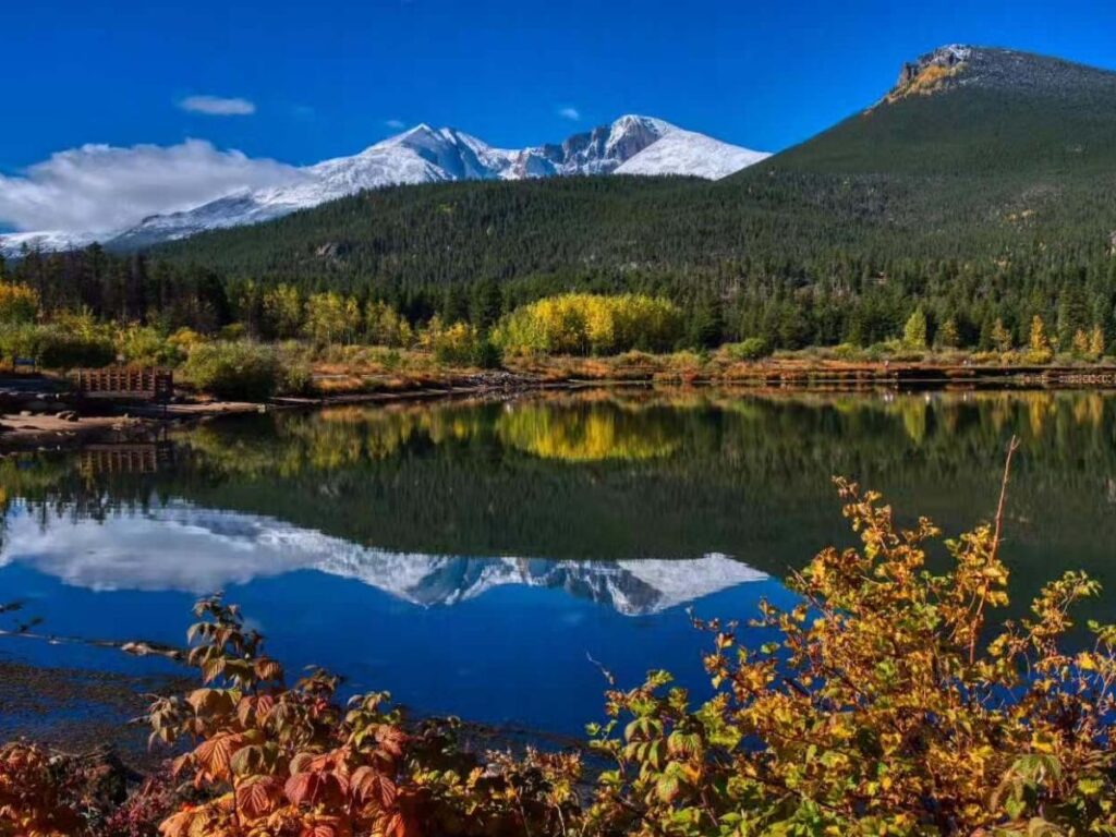 Walking path along Lake Estes with mountains in the background.