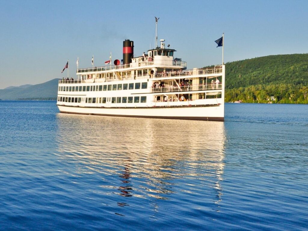 Boat cruise on Lake George passing islands and forested shoreline