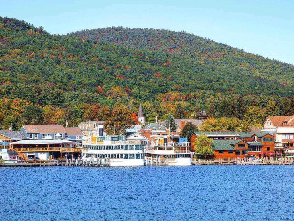 People walking along the Lake George Village waterfront near shops and the lake