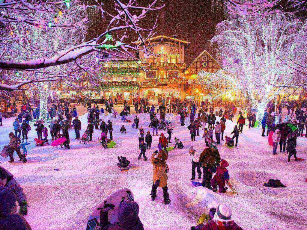 Snow-covered buildings and holiday lights in Leavenworth during winter