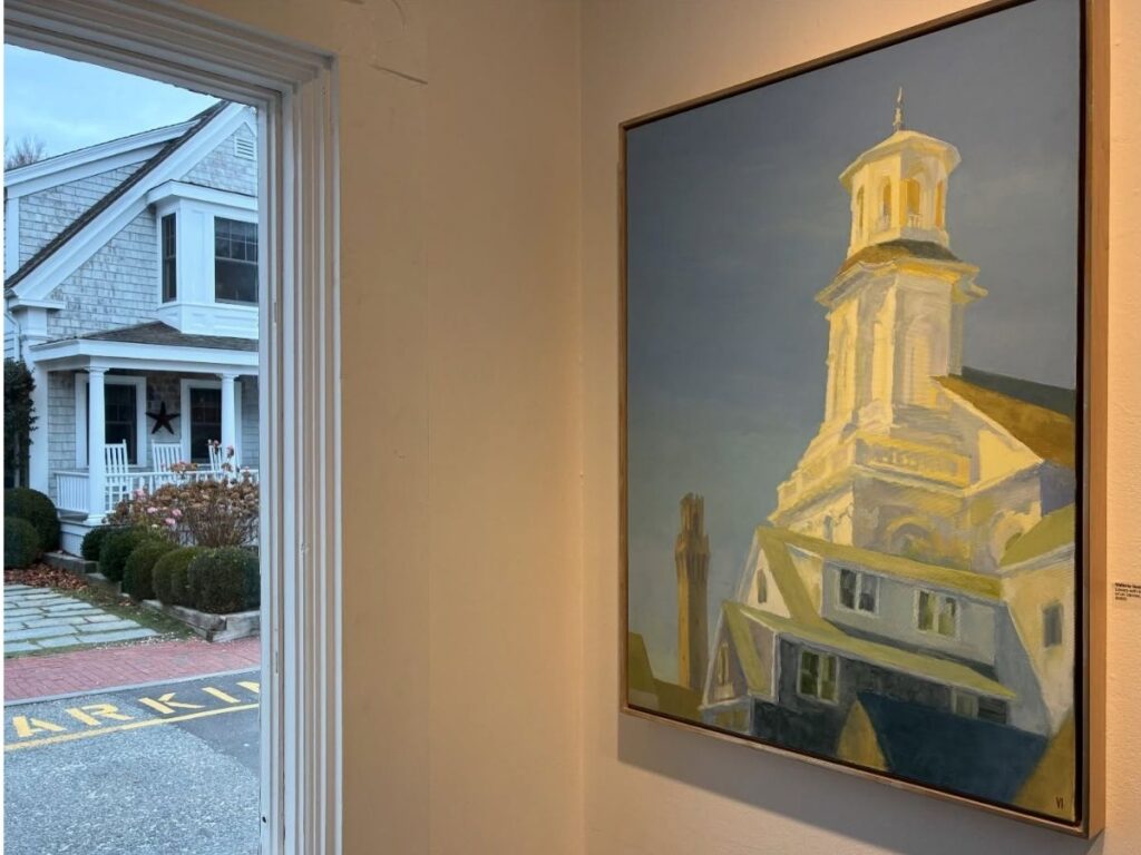 Small art galleries along a street in Provincetown with open doors and colorful signs