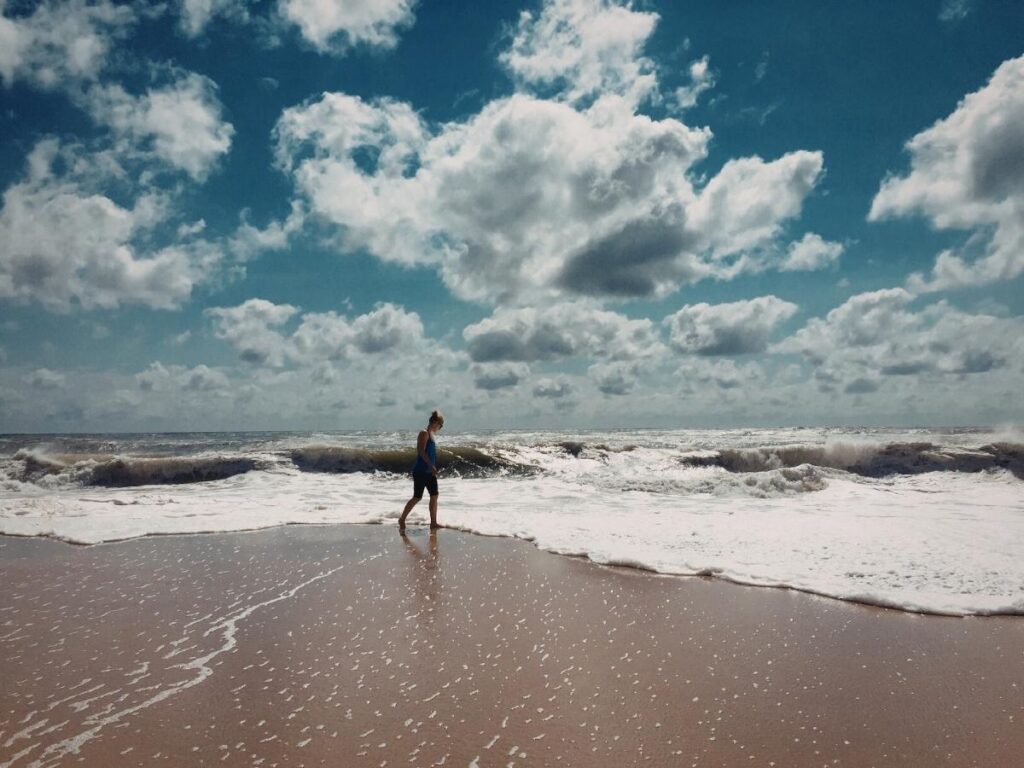 Solo traveler walking along the shoreline at Rehoboth Beach