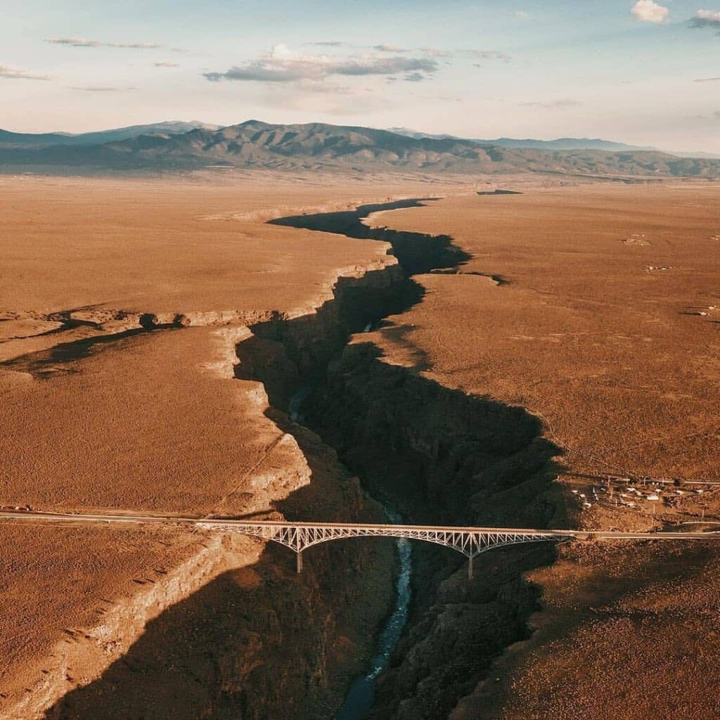 Sunset view from Rio Grande Gorge Bridge with golden canyon landscape below