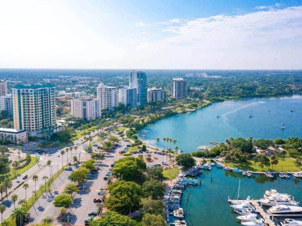 Walking path along the Sarasota bayfront with palm trees and calm water at sunset