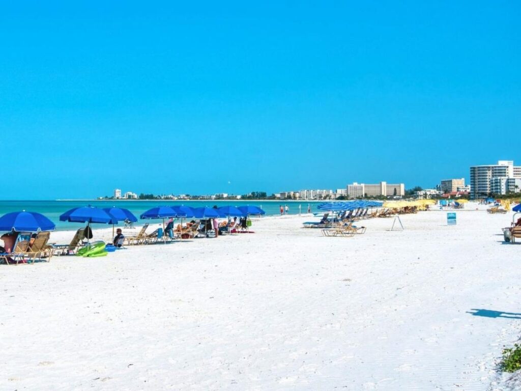 Sunset at Siesta Key Beach with people sitting along the wide shoreline